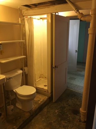 Scary bathroom before. Notice the slanted floor and slab to make the toilet level.